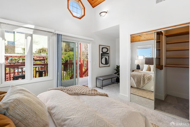 carpeted bedroom with baseboards, access to exterior, and a towering ceiling