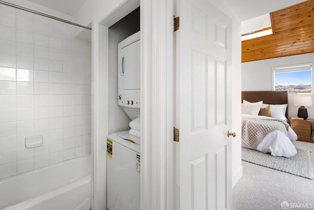 laundry room featuring carpet, stacked washer and clothes dryer, and laundry area