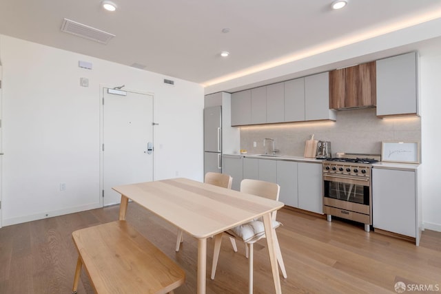 dining space with light wood-type flooring and sink