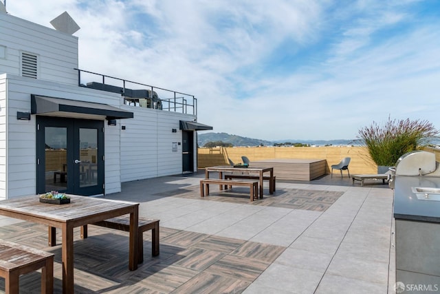 view of patio / terrace featuring a mountain view and french doors