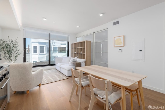 dining area with electric panel and hardwood / wood-style floors