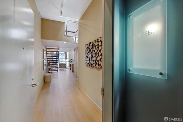 hall featuring a high ceiling and light hardwood / wood-style floors