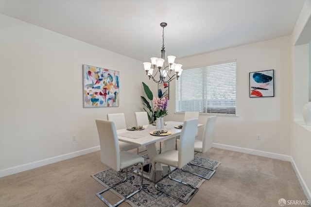 carpeted dining room with a chandelier