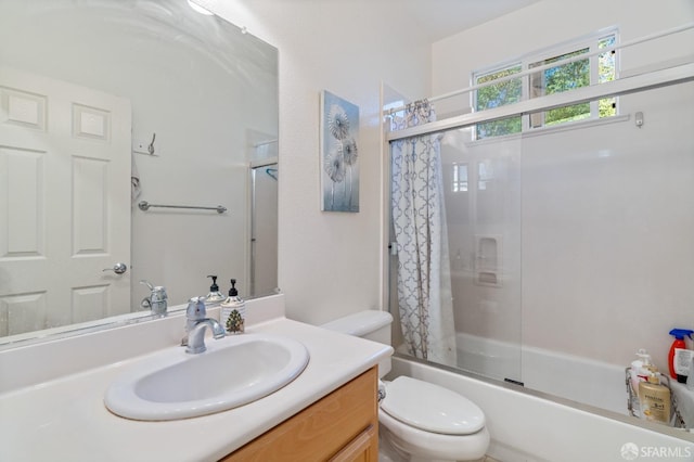 full bathroom featuring combined bath / shower with glass door, vanity, and toilet