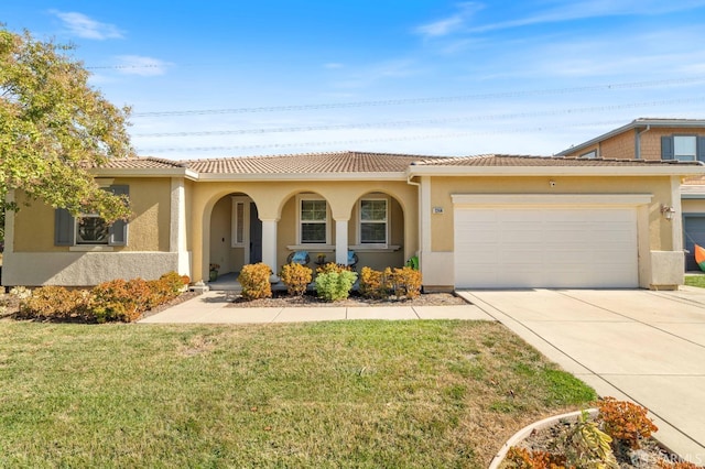 mediterranean / spanish house with a garage and a front lawn