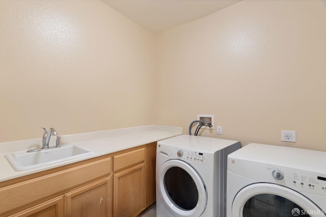 washroom featuring sink, cabinets, and separate washer and dryer