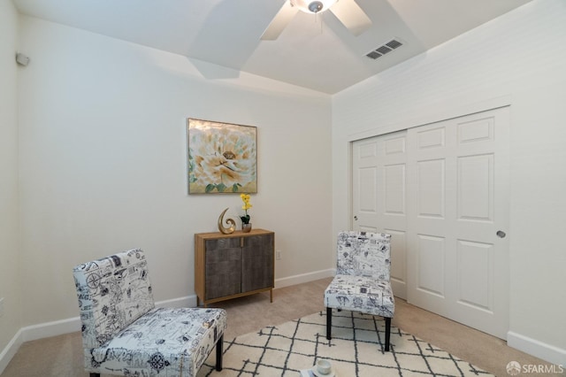 sitting room featuring ceiling fan and light carpet