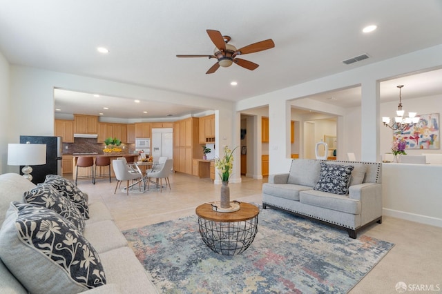 living room featuring ceiling fan with notable chandelier