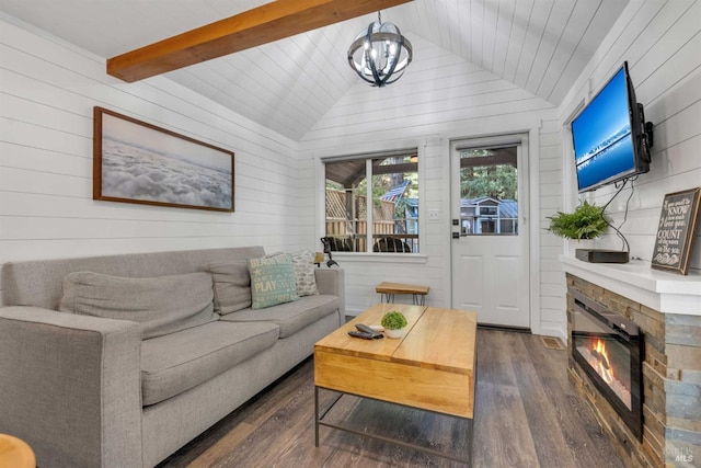 living area with lofted ceiling with beams, a glass covered fireplace, wood finished floors, and a notable chandelier