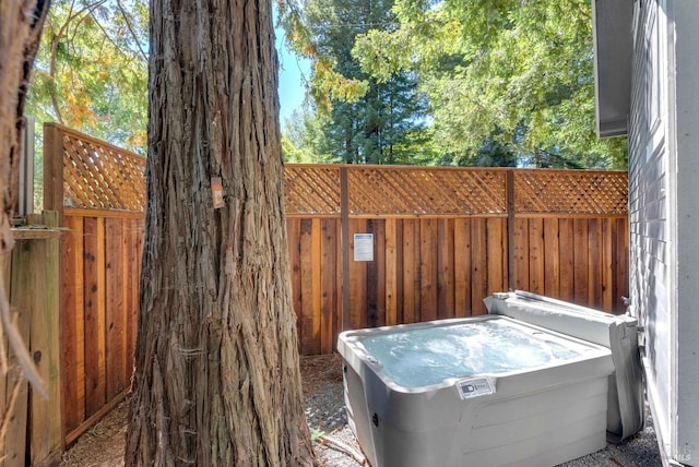 exterior space with fence and a hot tub