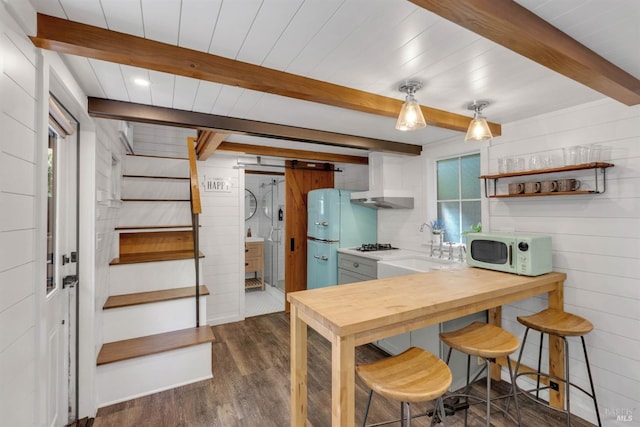 kitchen with white appliances, dark wood-style flooring, wood walls, a sink, and beamed ceiling