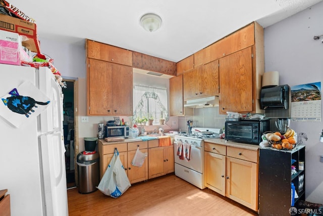 kitchen featuring decorative backsplash, light wood-type flooring, white appliances, and sink