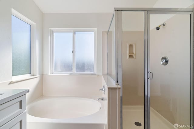 bathroom featuring a shower stall, a bath, and vanity