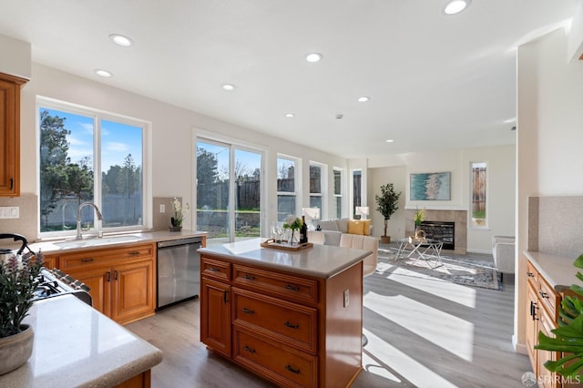 kitchen with a center island, open floor plan, light countertops, and stainless steel dishwasher