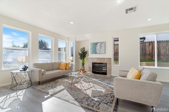 living room featuring baseboards, visible vents, wood finished floors, a fireplace, and recessed lighting