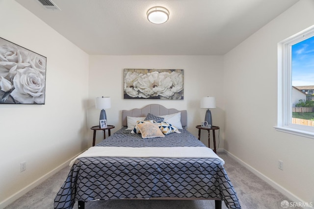 bedroom featuring light carpet, visible vents, and baseboards