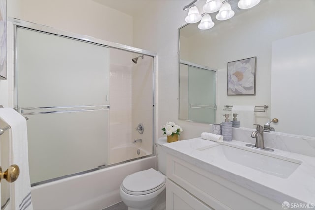 bathroom with shower / bath combination with glass door, vanity, and toilet