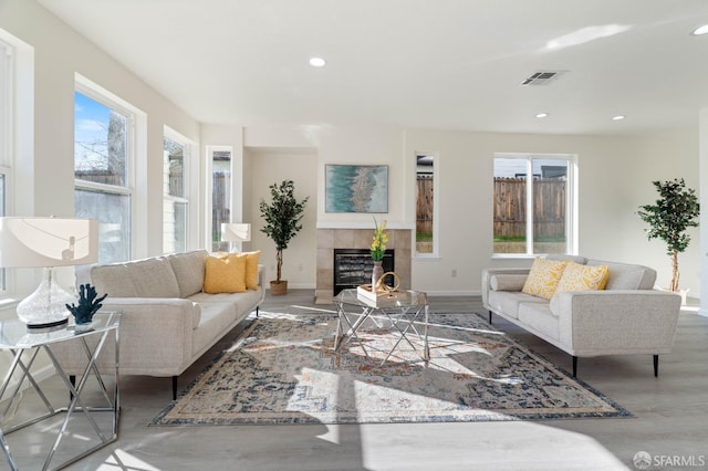 living room with visible vents, baseboards, a tile fireplace, wood finished floors, and recessed lighting