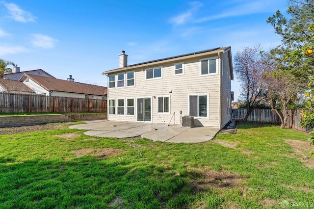 rear view of house featuring a yard, a patio, a chimney, cooling unit, and a fenced backyard