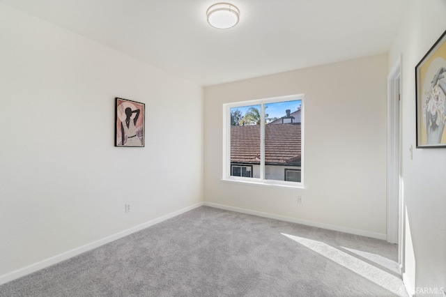 spare room with light colored carpet and baseboards