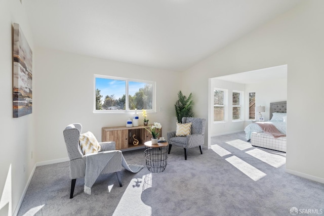 sitting room with lofted ceiling, light colored carpet, and baseboards