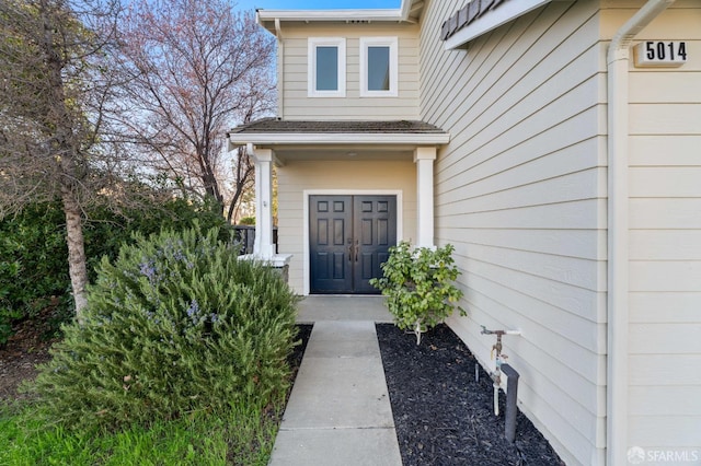 entrance to property with roof with shingles