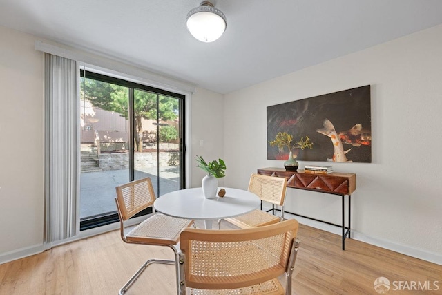 dining space with baseboards and wood finished floors