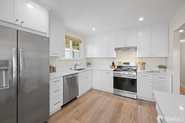 kitchen with stainless steel appliances, a sink, light countertops, and under cabinet range hood