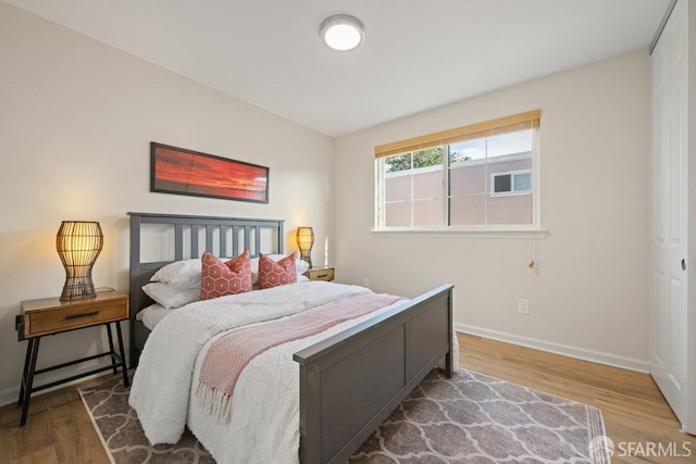 bedroom featuring baseboards and wood finished floors