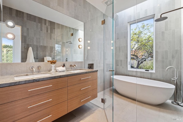 full bath featuring visible vents, a sink, tile walls, and a shower stall