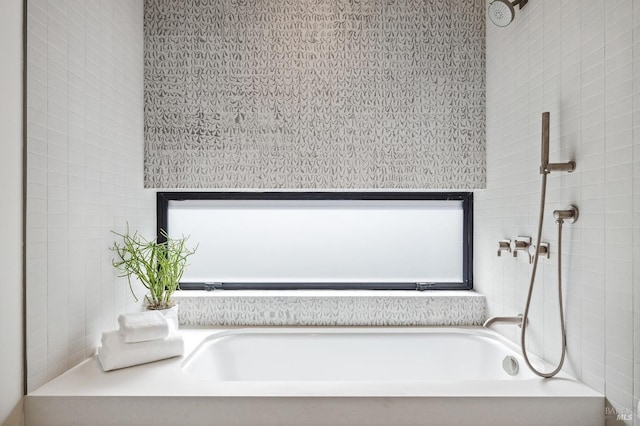 bathroom featuring a wealth of natural light and a bath