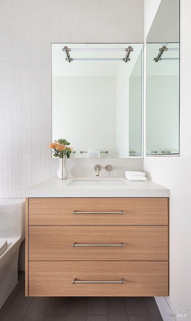 bathroom with toilet, tile patterned flooring, and vanity