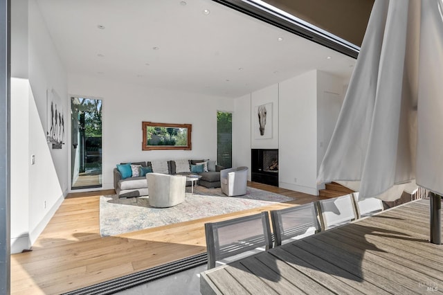 living room with baseboards, light wood finished floors, a fireplace, and recessed lighting