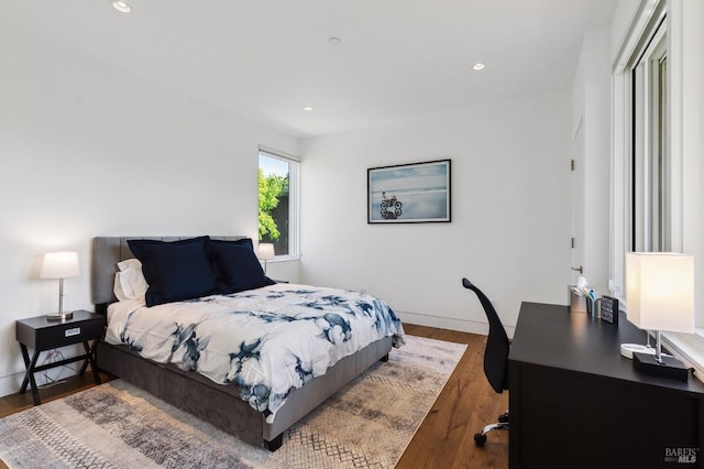 bedroom featuring baseboards, wood finished floors, and recessed lighting