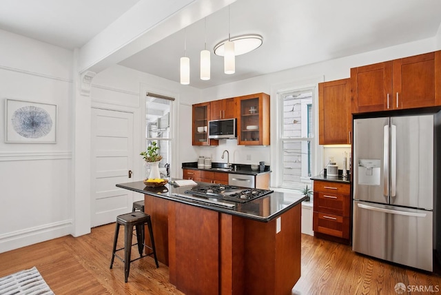 1483 Guerrero St, San Francisco, CA 94110 - kitchen with appliances with stainless steel finishes, dark countertops, wood finished floors, glass insert cabinets, and a breakfast bar