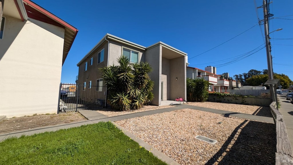 exterior space featuring stucco siding and fence