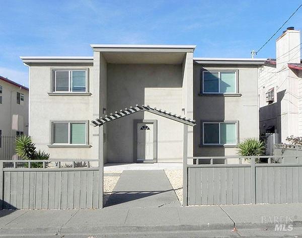 multi unit property with stucco siding and fence