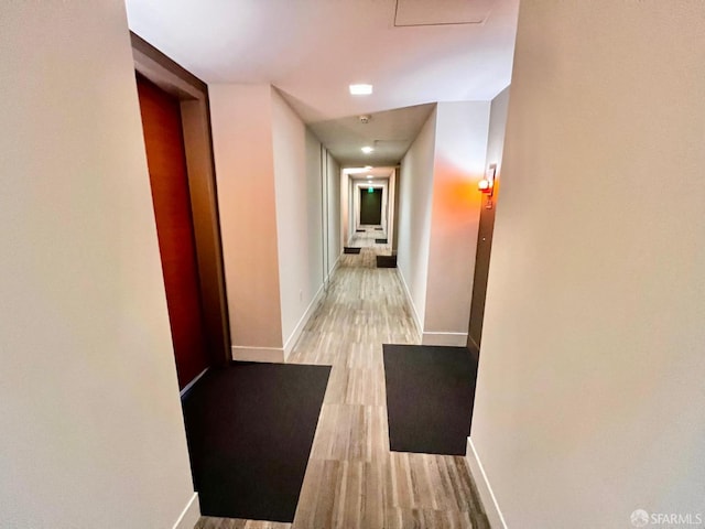 hallway with light hardwood / wood-style flooring