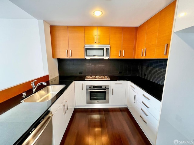 kitchen featuring appliances with stainless steel finishes, decorative backsplash, sink, and white cabinetry