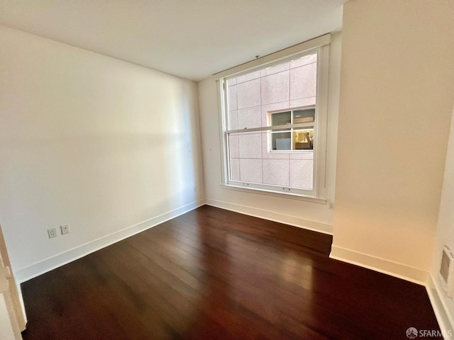 empty room with dark hardwood / wood-style flooring