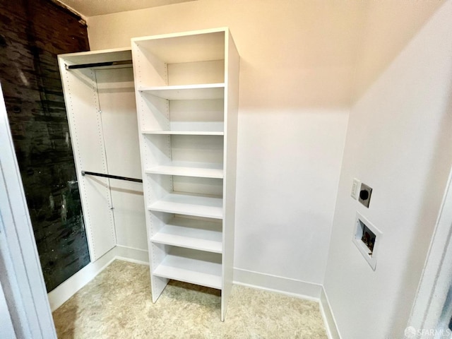 spacious closet featuring light colored carpet