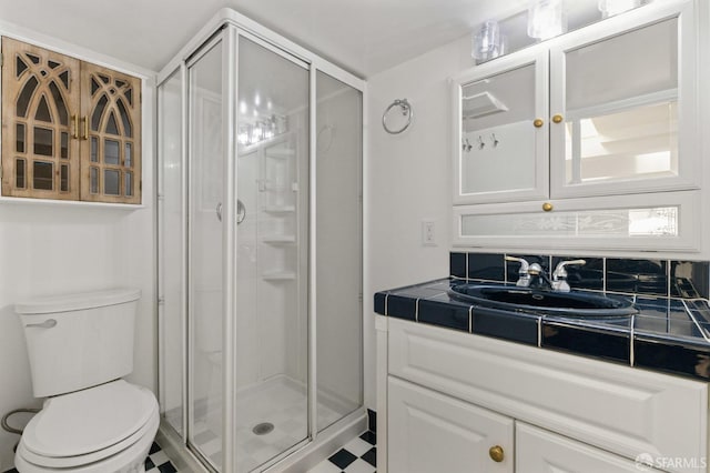 full bathroom featuring tile patterned floors, a shower stall, toilet, and vanity