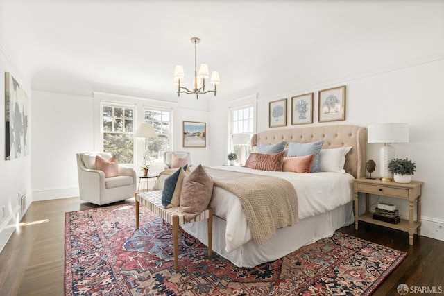 bedroom featuring a chandelier, crown molding, baseboards, and wood finished floors