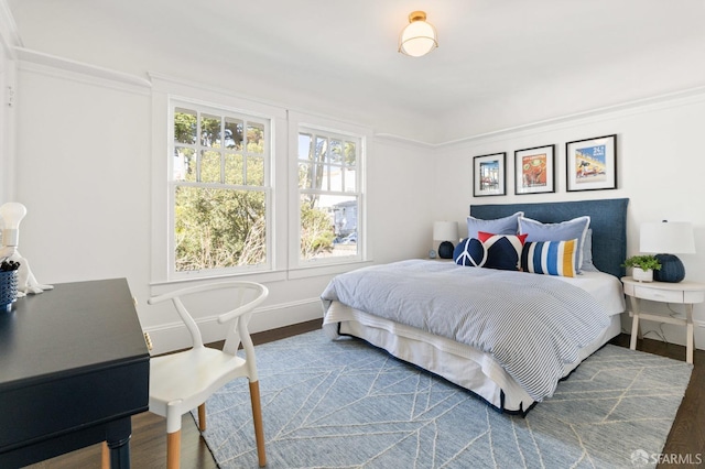 bedroom with baseboards and wood finished floors