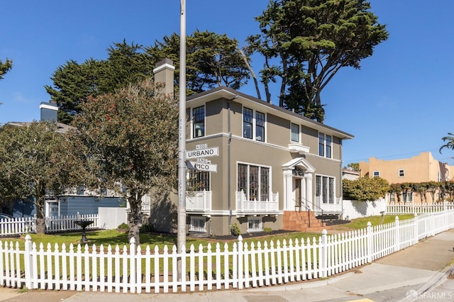 view of front facade featuring a fenced front yard, a front yard, and stucco siding