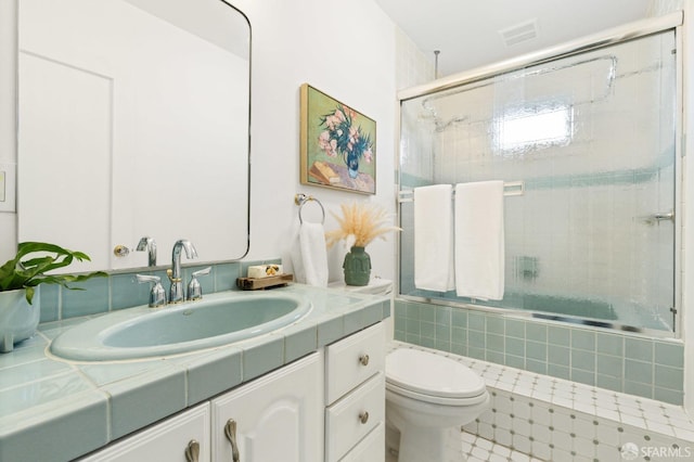 full bath featuring toilet, visible vents, tiled shower / bath, and vanity