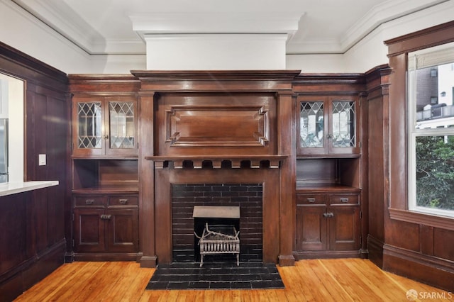 bar featuring light wood-type flooring, wood walls, stainless steel refrigerator, and crown molding