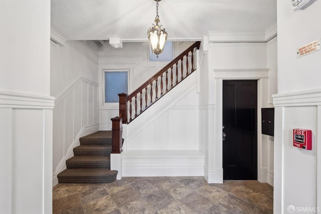 stairs with an inviting chandelier