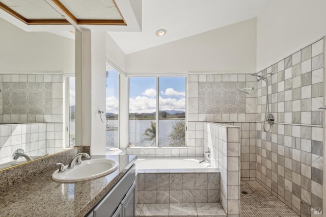 full bathroom with vanity, lofted ceiling, a relaxing tiled tub, and tiled shower