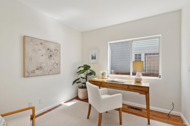 home office with visible vents, baseboards, and wood finished floors